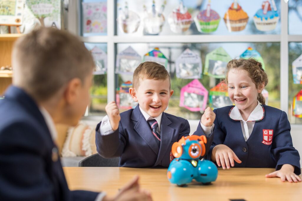 A junior male and female student from Northholm Grammar observing a robot